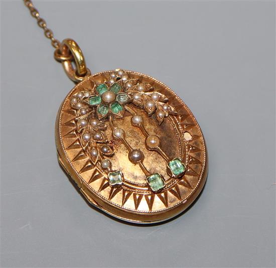 A Victorian yellow metal, emerald and seed pearl set oval locket, 35mm.